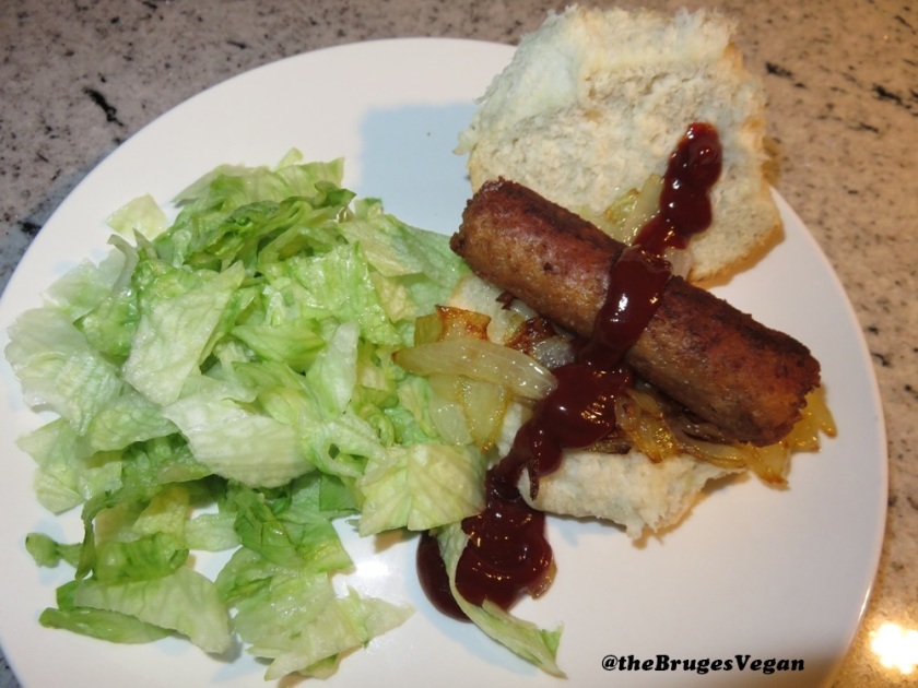 Linda McCartney sausage, with fried onions, bread and iceberg lettuce